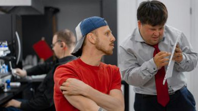 Mensch mit Down Syndrom im Gespr&auml;ch mit Kollegen.