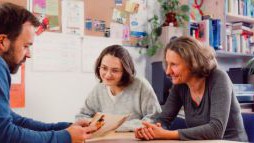 Beratungssituation mit drei Personen in einem B&uuml;ro.